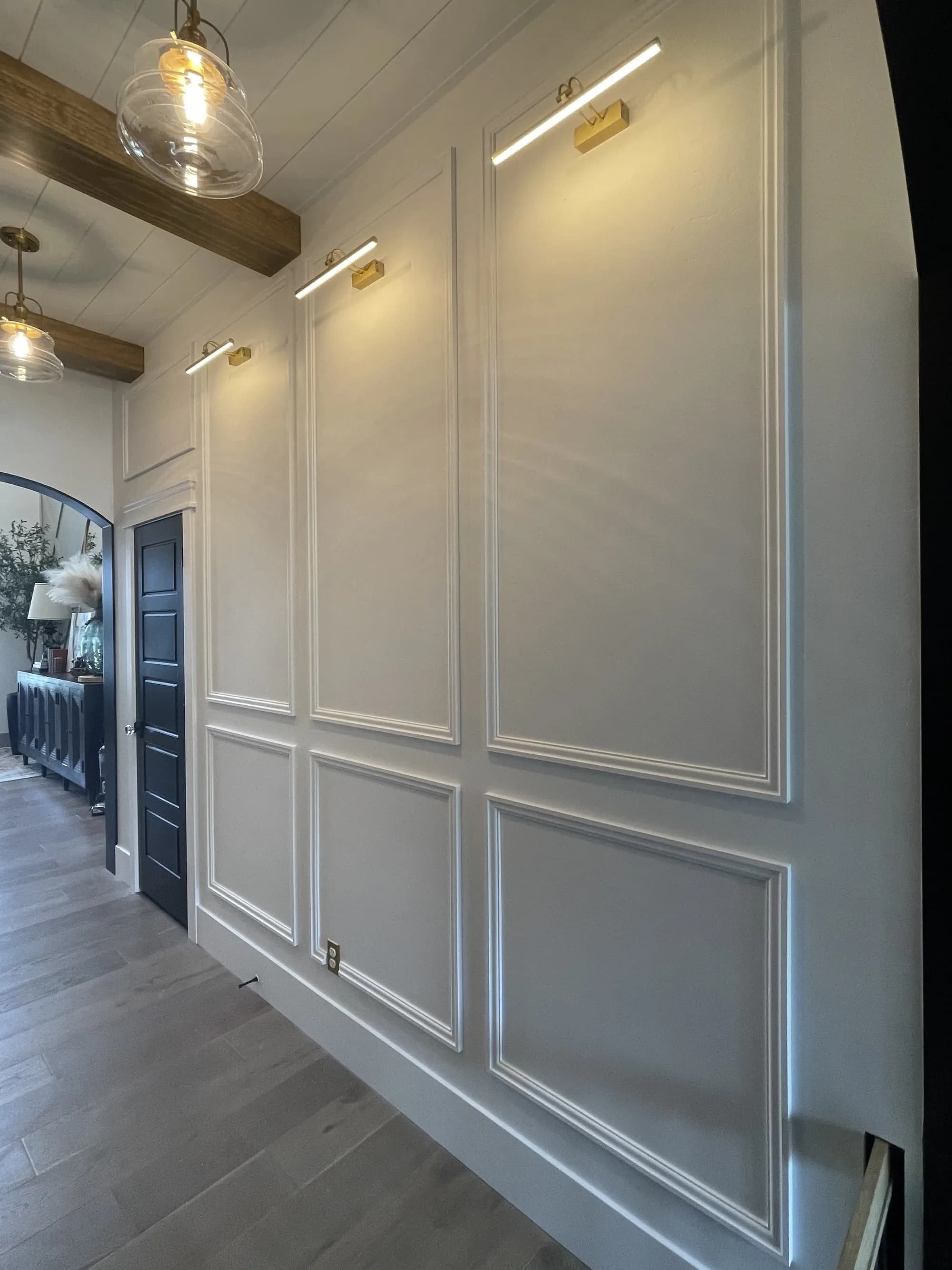 Custom picture-frame wall molding with wood beam and picture lights by BK Toolbox
