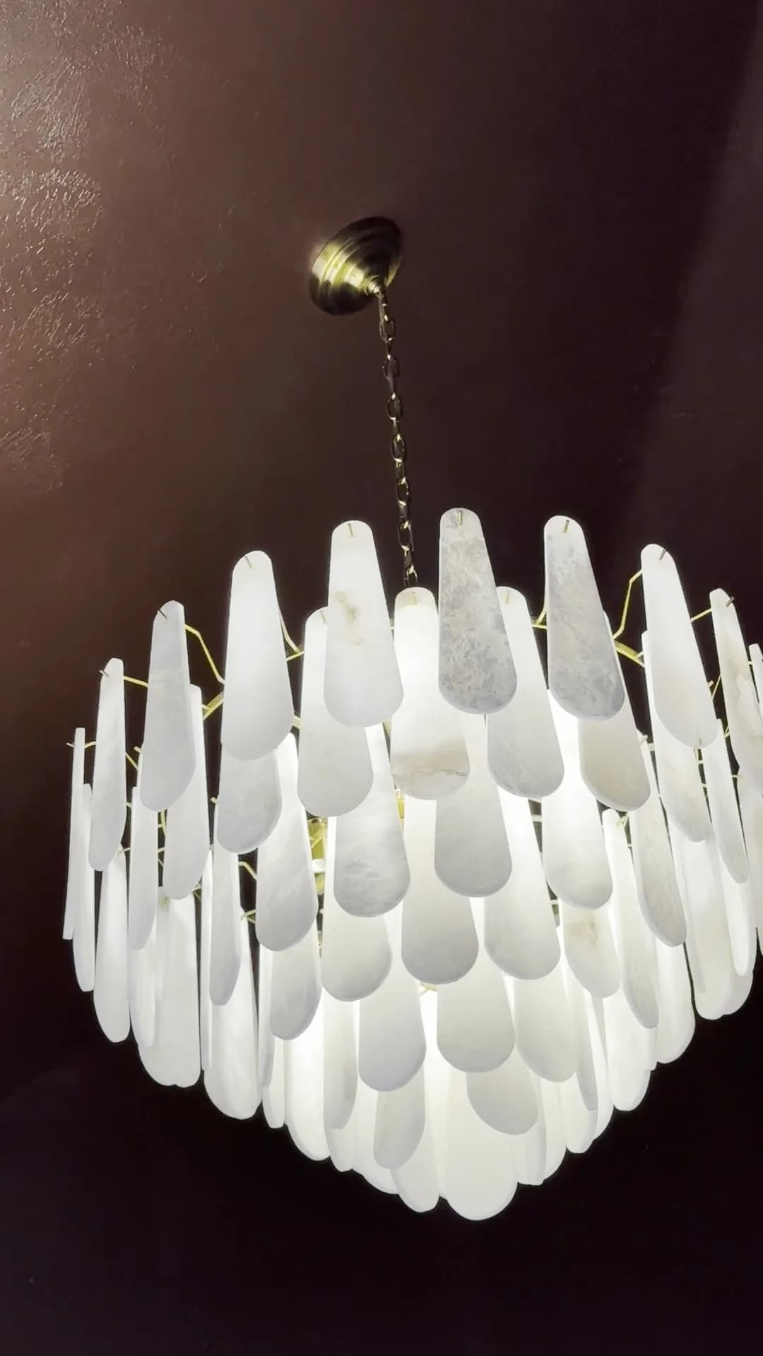 Capiz-shell chandelier in a terracotta paneled room by BK Toolbox